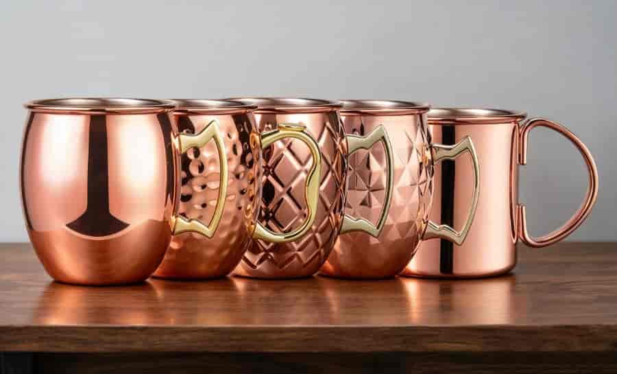 Five styles of stainless steel Moscow Mule mugs: classic, hammered, patterned, diamond-textured, and cylindrical